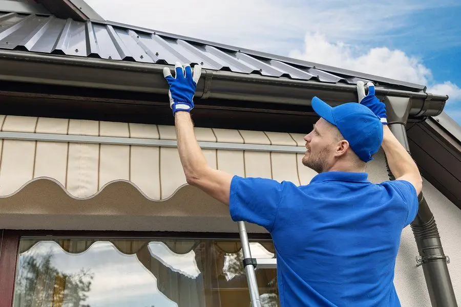 Removing compacted debris from a gutter by hand