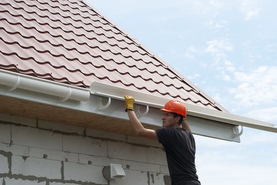 Installing a new gutter along a roof edge